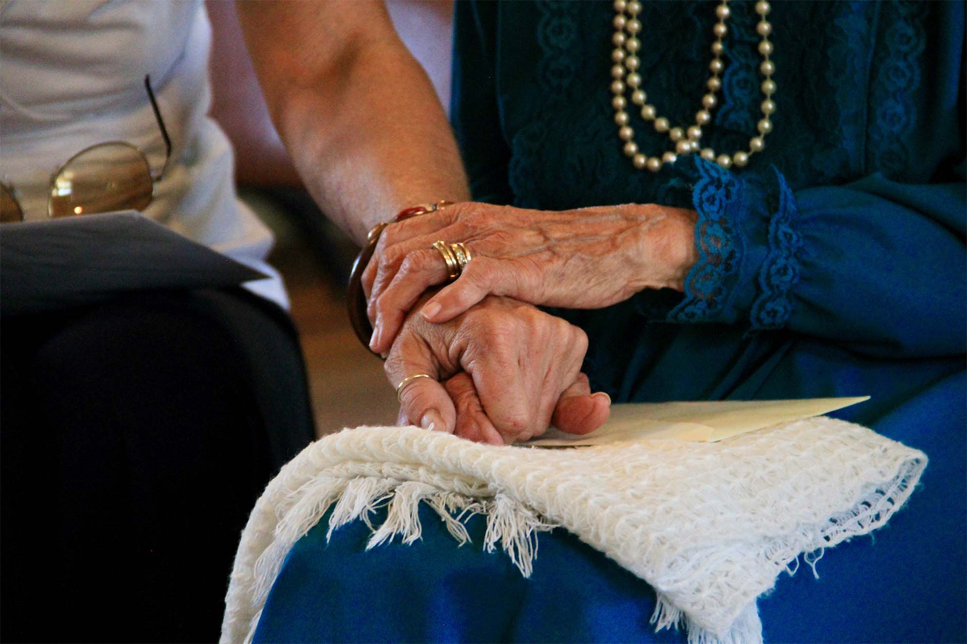 residents holding hands with loved one