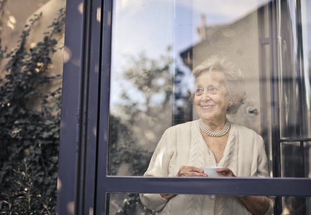 resident looking out the window smiling