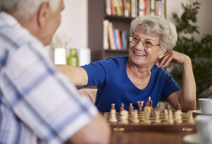 Grandmother and grandfather playing chess for relaxation