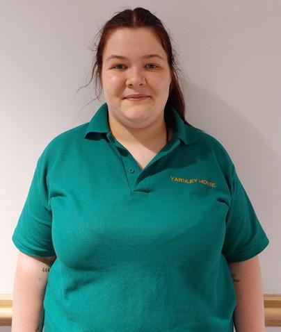 lady in green polo shirt posing for staff photo