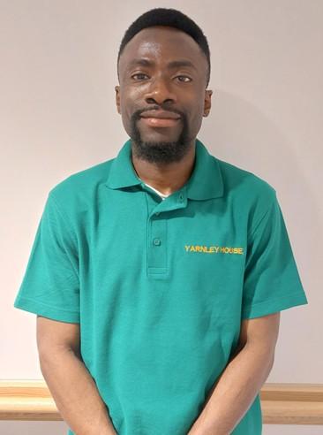 man in green polo shirt posing for staff photo