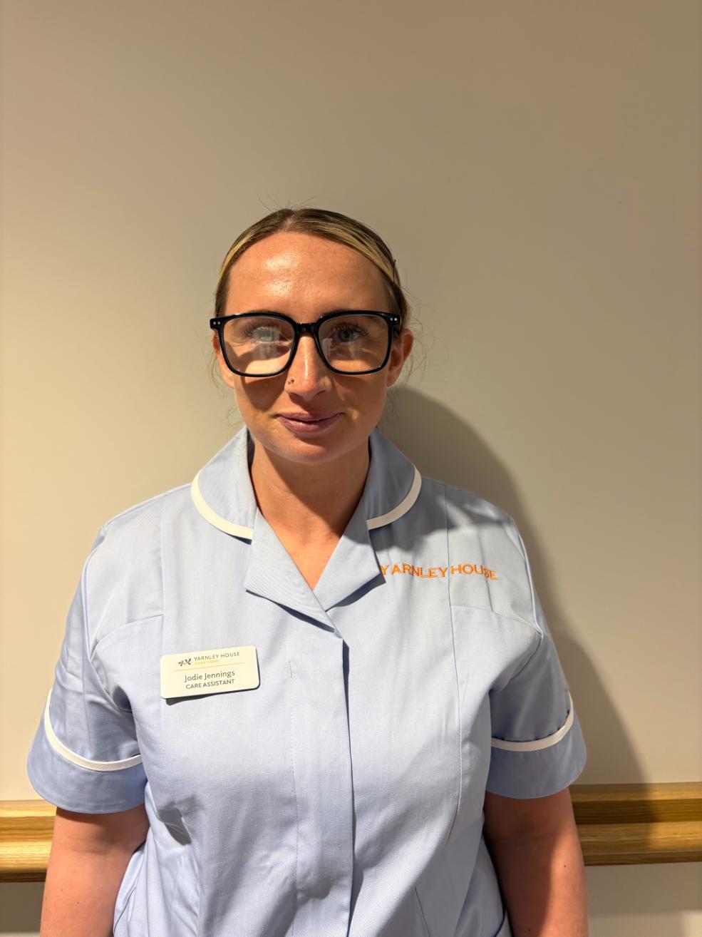 lady with glasses posing for staff photo