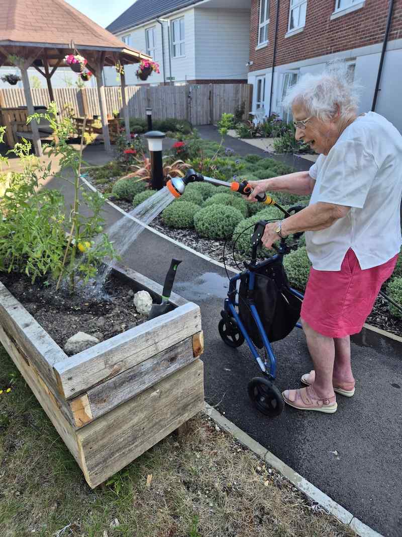 one of our female residents watering the plants outside
