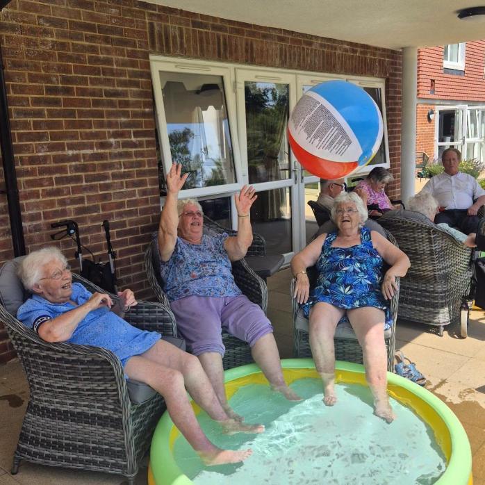 older ladies sat in a garden with a beach ball